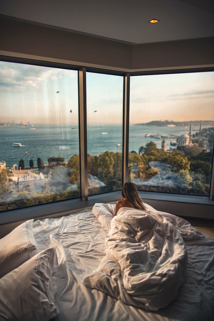 why-choose-us Relaxing in a cozy hotel room with stunning views of the Bosphorus at sunset in Istanbul, Turkey.